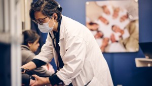 Jinny Cho, Nurse Practitioner for the Community Care Coach, delivers a health screening to a patient.