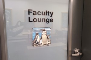 A glass door labeled "Faculty Lounge" features a small illustration of penguins.