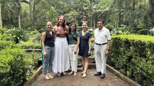 Five people stand on a path in a jungle, surrounded by trees