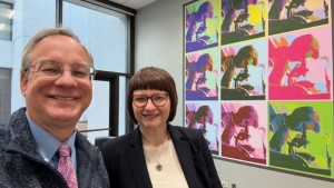 Aron with Associate Professor Joanna Dabrowska, PhD, PharmD, in front of a large format version of her piece, Dr. Rosalind Franklin Polychromatic, which is now on the wall of Aron’s office.