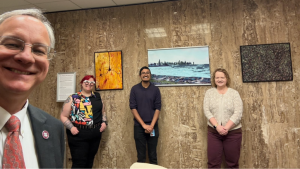 From left, Aron with GM O’Hare MS ’25, CMS ’29, Viral Mistry, PhD ‘25, and Emily Reisenbigler, Sr. Research Specialist and their Art from the Benchtop pieces in the lobby of Aron’s office. 