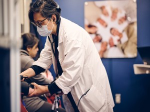 Jinny Cho, Nurse Practitioner for the Community Care Coach, delivers a health screening to a patient.