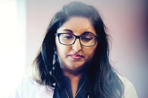 Two healthcare professionals in white coats focus intently on their tasks.