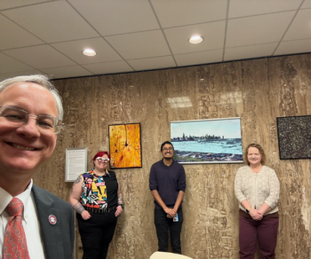 From left, Aron with GM O’Hare MS ’25, CMS ’29, Viral Mistry, PhD ’25, and Emily Reisenbigler, Sr. Research Specialist and their Art from the Benchtop pieces in the lobby of Aron’s office.